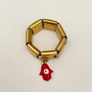 Makroaufnahme von Gold-Edelstahl-Gliederarmband mit rotem Hamsa-Hand und Evil-Eye-Anhänger