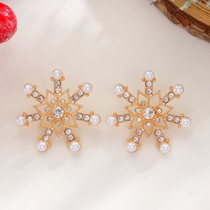 Detail of snowflake earrings with crystals and pearls on a festive Christmas background