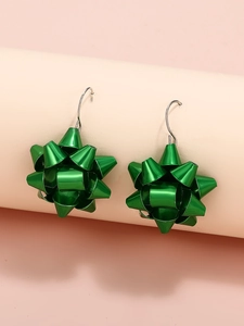 Dettaglio degli orecchini a fiore di Natale verde metallizzato su supporto rosa