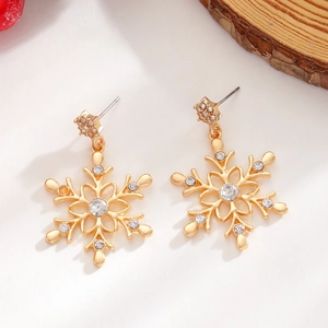 Detailed view of gold snowflake earrings featuring central crystal and white pearl accents