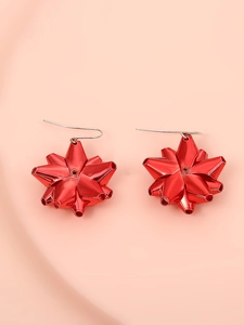 Dettaglio di orecchini natalizi a forma di stella rossa con ganci lunghi eleganti