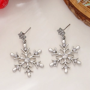 Macro view of silver snowflake earrings with inlaid crystals and pearl detail