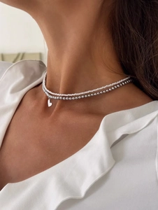 Double-layered beaded necklace with a small heart pendant on a delicate silver chain