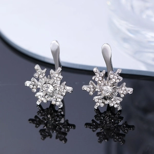 Detailed view of silver snowflake earrings with cubic zirconia and round center stone