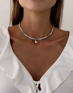 Double-layered silver beaded necklace with white heart pendant on a ruffle top