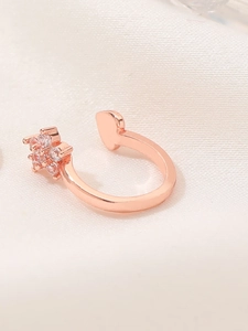 Macro shot of rose gold open ring with sparkling heart and crystal flower detailing