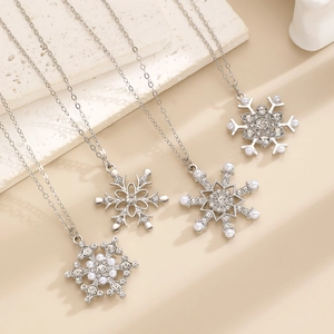Detailed view of silver snowflake necklaces with rhinestones and faux pearls on stones