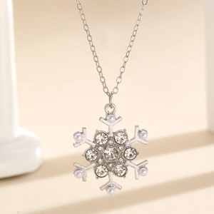 Macro shot of a winter snowflake pendant necklace with sparkling rhinestones and small pearls