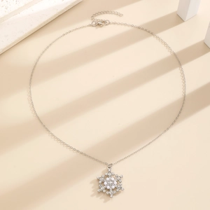 Detailed macro shot of silver snowflake necklace with pearls and sparkling crystals