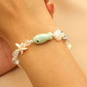 Close-up of a hand-woven starfish and fish ceramic beaded bracelet for summer vacations
