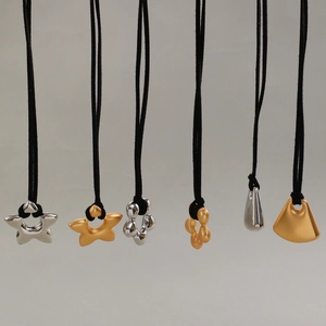 Détails de divers pendentifs géométriques minimalistes en finitions argent et or mat