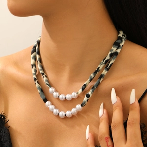 Détail du collier double couche avec imprimé léopard et perles blanches élégantes