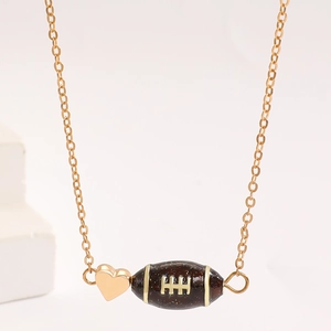 Makroaufnahme der goldenen Football-Halskette mit Glitzeranhänger und kleinem Herz