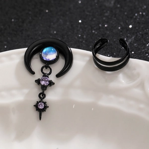 Detail view of black gothic crescent earring with blue gemstone and matching ear cuffs