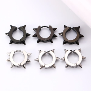 Detail view of punk spike rivet ear cuffs in black and silver finishes on white background