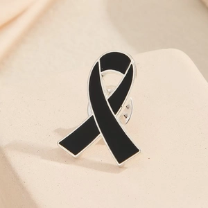 Formal black enamel ribbon lapel pin with silver metal trim for mourning and memorial events