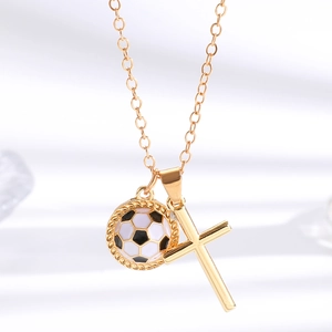 Detail einer goldenen Halskette mit Kreuz und schwarz-weiß emailliertem Fußball-Anhänger