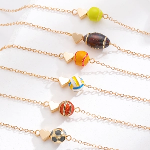Detailansicht der herzförmigen Sportanhänger mit goldenem Basketball- und Fußball-Charme