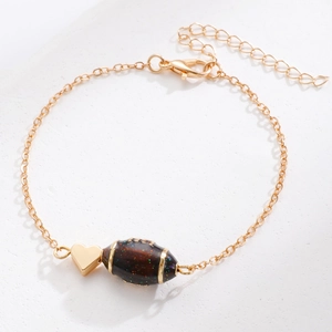 Detail von goldenem Herzanhänger und glitzernder Rugbyperle an verstellbarer Kette
