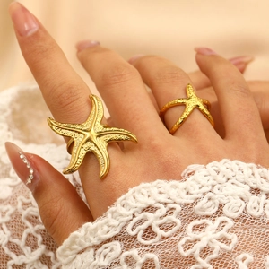 Macro detail of 18K gold starfish rings set with textured relief on gold metal