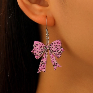 Close-up of model wearing pink leopard print bow earrings made of acrylic material