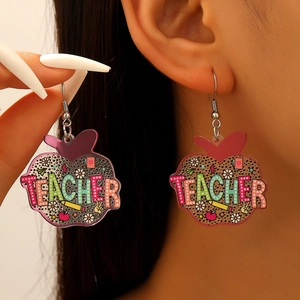 Detail view of acrylic apple earrings featuring leopard print and Teacher text lettering