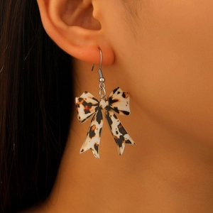 Chic leopard print bow earrings with acrylic design shown on a model's ear