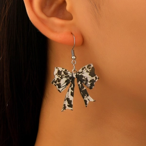 Detailed close-up of a leopard print bow earring on a model showing acrylic texture