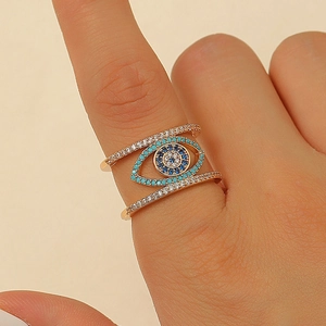 Close-up of a tiered gold Evil Eye ring with blue turquoise and sparkling white zircon