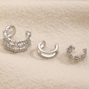 Dettaglio di tre ear cuff argento con cristalli incastonati e motivi floreali