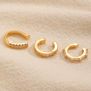 Macro di tre ear cuff dorati con zirconi cubici e design minimalista a forma di C aperta