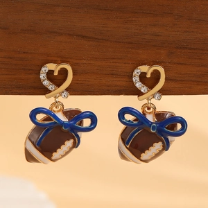 Detail von Rugby-Herz-Ohrringen mit blauen Schleifen und Strass auf Holzdisplay