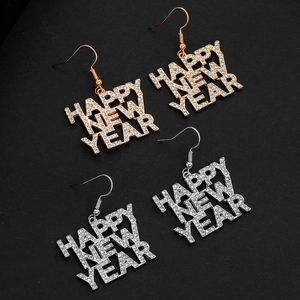 Macro-opname van gouden en zilveren Happy New Year oorbellen met glanzende strassteentjes