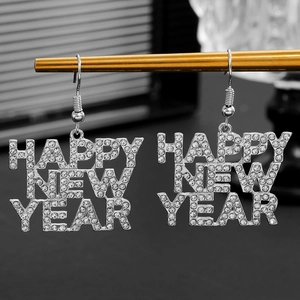 Macro-opname van zilveren Happy New Year oorbellen met sprankelende kristalstenen
