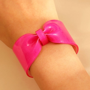 Close-up of stylish bright pink resin bow cuff bracelet with sparkling silver glitter