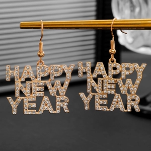 Close-up van gouden Happy New Year oorbellen met sprankelende strassteentjes
