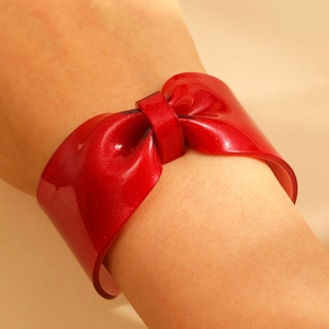 Detail view of bold red glitter resin bow cuff bracelet showing high gloss texture and style