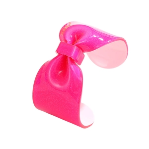 Detail view of pink glitter resin bow bracelet with shiny translucent finish and open cuff