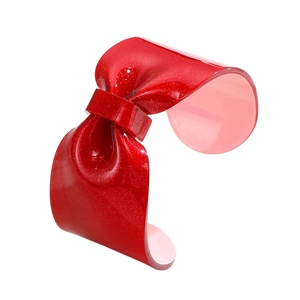 Sparkly red resin bow cuff bracelet with glitter finish and open minimalist design