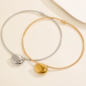 Minimalist gold and silver snake chain necklaces with polished oval geometric pendants