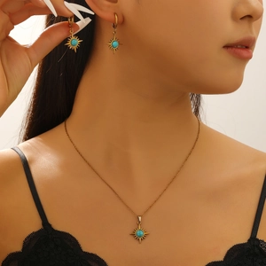Detailansicht eines Vintage-Schmucksets mit Sonnenstern-Halskette und Türkis-Ohrringen
