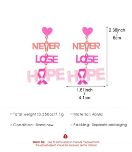 Détail des boucles d'oreilles ruban rose cancer du sein en acrylique avec texte Never Lose Hope