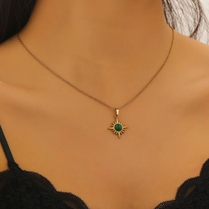 Detail der goldenen Vintage-Sternenhalskette mit grünem Edelstein an einem Model