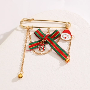 Détail de broche de Noël avec nœud en ruban rouge et vert et pendentif Père Noël émaillé