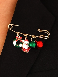 Détail d'une broche de Noël avec Père Noël et glands sur le revers d'un blazer noir