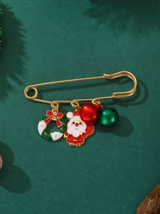 Détail d'une broche de Noël dorée avec pendentifs Père Noël, couronne et clochettes