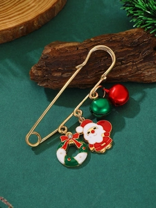 Détail d'une broche épingle de Noël avec des breloques Père Noël et cloches festives