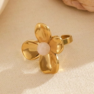 Macro detail of gold flower ring featuring a pink natural stone and polished metal petals