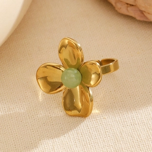 Macro detail of golden flower ring featuring a green stone and adjustable open band