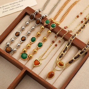 Detailansicht von vier Retro-Tigerauge-Halsketten mit Gold- und Silberkettendesigns